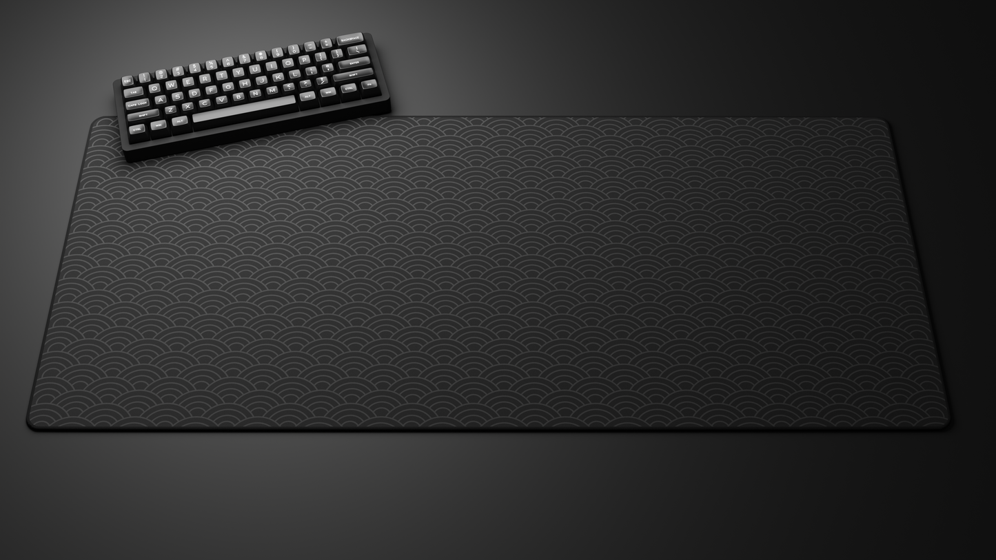 Black keyboard on a large patterned black desk mat