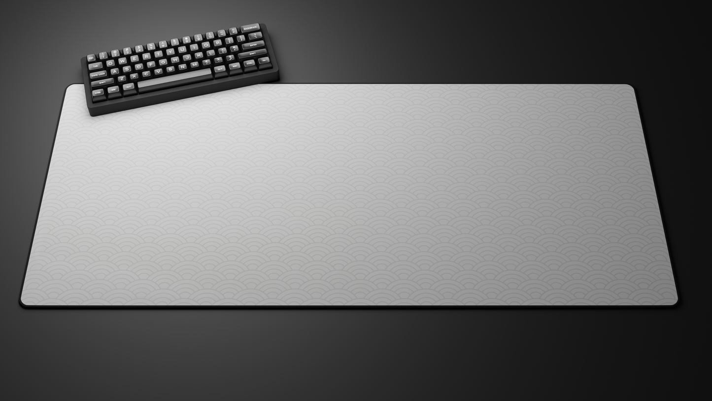 Black keyboard on large gray desk mat